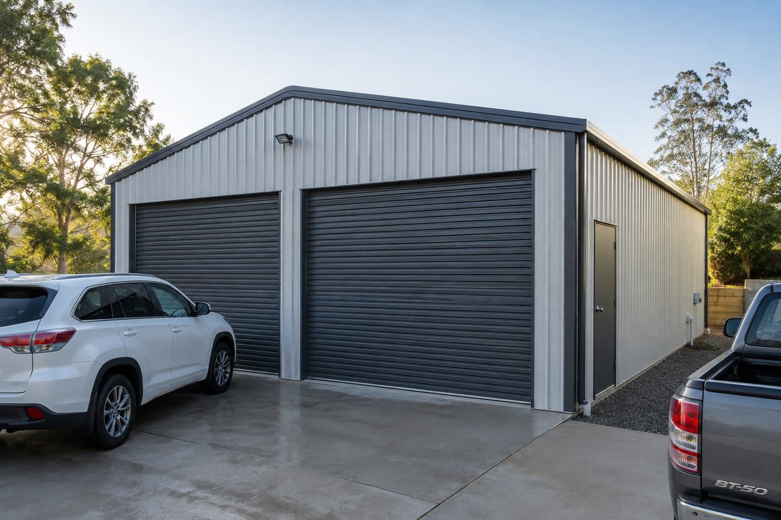 Compact two-car metal garage with two roller doors