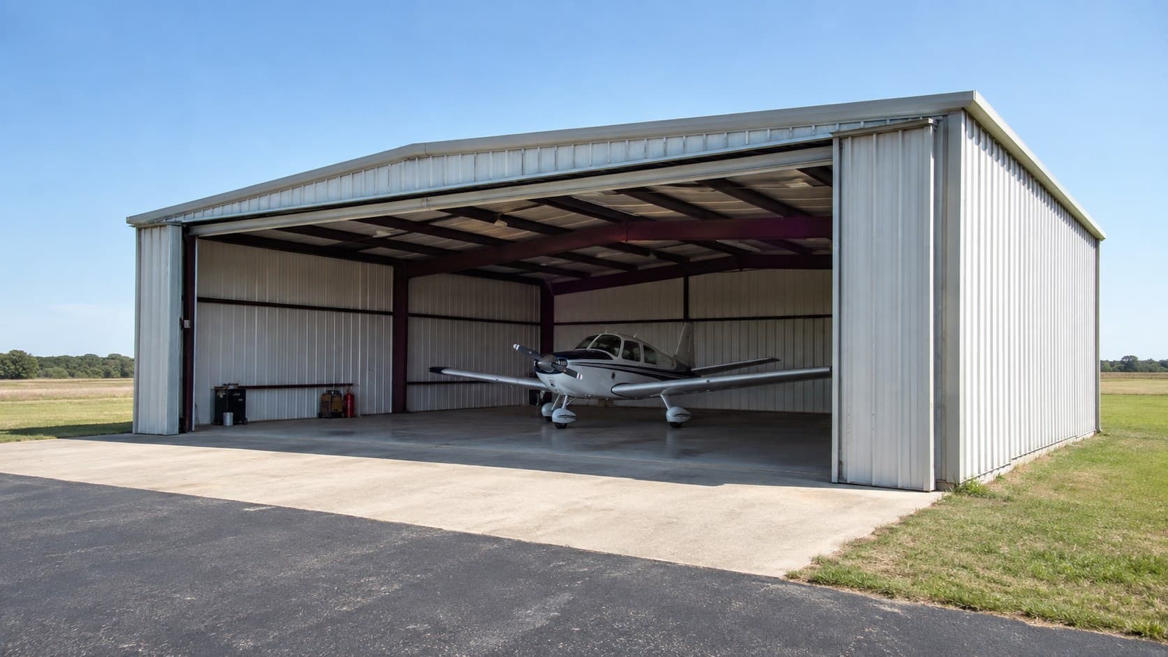 Compact clear-span aircraft hangar with a wide sliding door