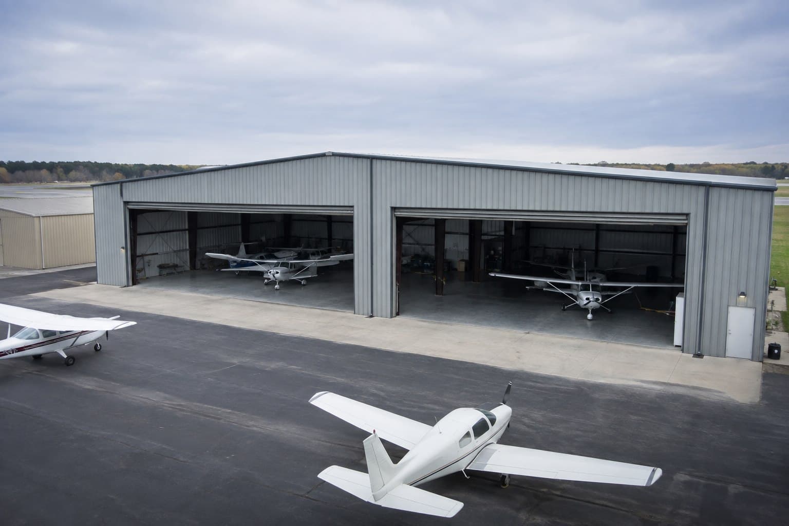 Multi-bay aircraft hangar photographed from an elevated exterior angle