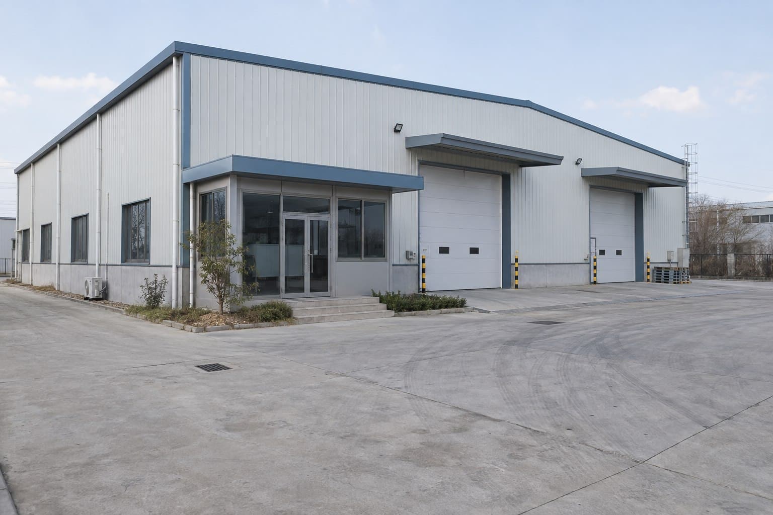 Completed prefabricated steel building with warehouse doors and office entrance